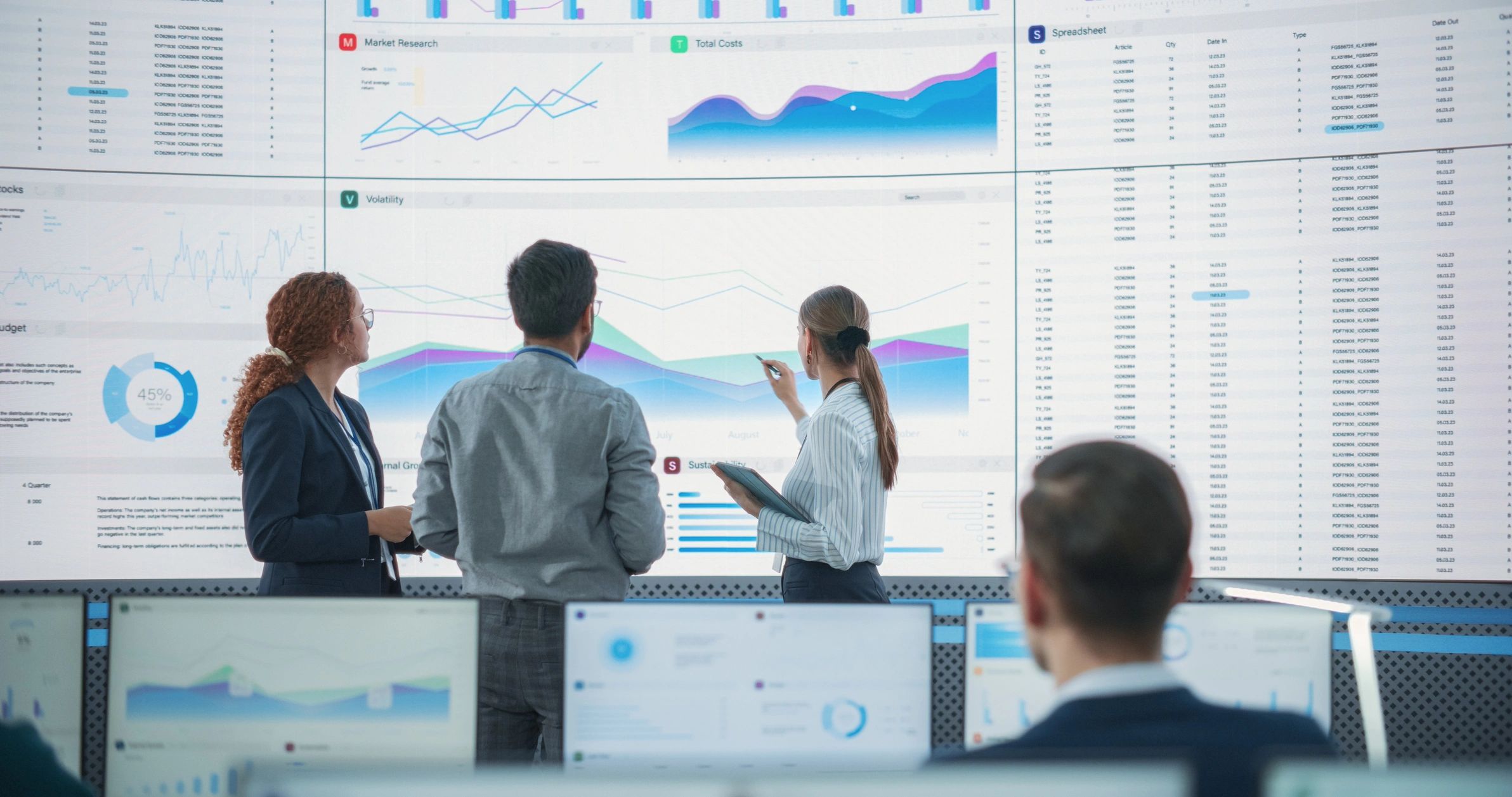 Business team reviewing data on a large digital screen